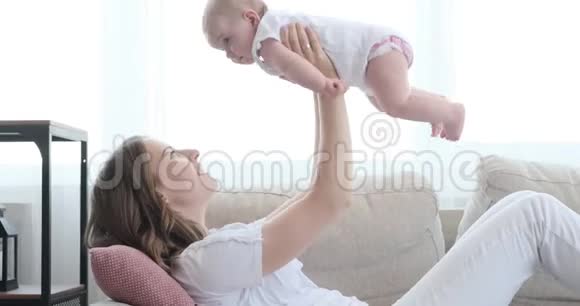 妈妈在家里亲吻和举起她的宝贝女儿视频的预览图