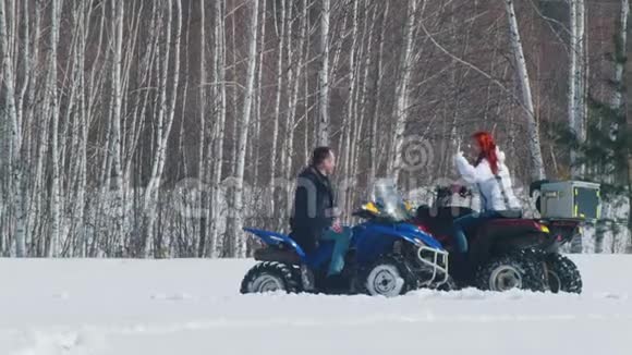 冬天的森林一男一女坐在雪地摩托上互相击掌视频的预览图
