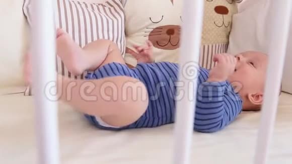 可爱快乐6个月小男孩躺着玩视频的预览图