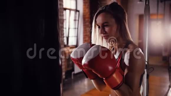 一个女拳击手站在拳击袋前面视频的预览图