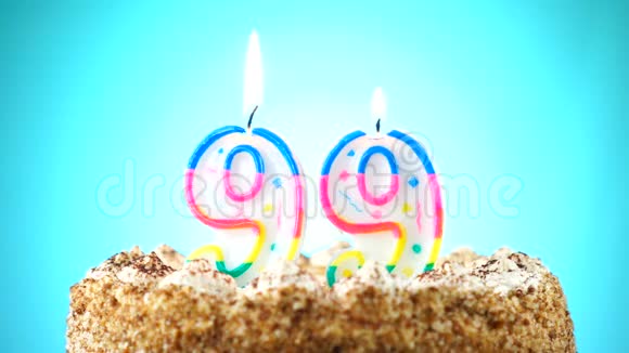 生日蛋糕和燃烧的生日蜡烛99号背景更改颜色视频的预览图