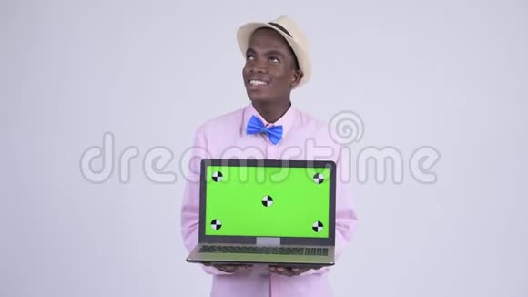 年轻快乐的非洲游客一边展示笔记本电脑一边思考视频的预览图