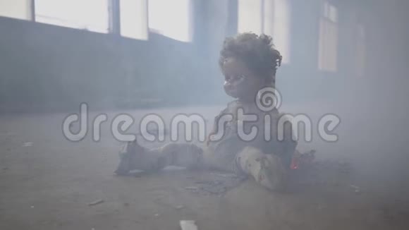 两个男孩在背景中的烟雾中穿过黑暗的房间恐怖的娃娃在地板上燃烧视频的预览图