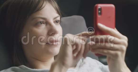 女人在沙发上用手机视频的预览图