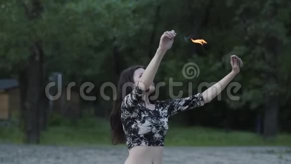 年轻美丽的女孩表演一场表演火焰站在森林前面有技巧的炉火艺术家呼气视频的预览图