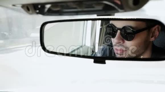 汽车后视镜里一个英俊的年轻人的脸视频的预览图