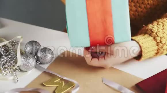 在圣诞礼物上系上红丝带的女人视频的预览图