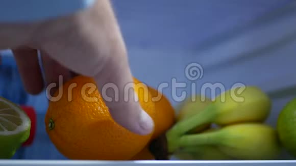 厨房里的男人从冰箱里拿新鲜水果当早餐视频的预览图
