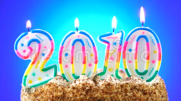 用燃烧的生日蜡烛做生日蛋糕2010年背景变化颜色视频的预览图