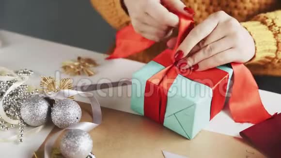在圣诞礼物上系上红丝带的女人视频的预览图