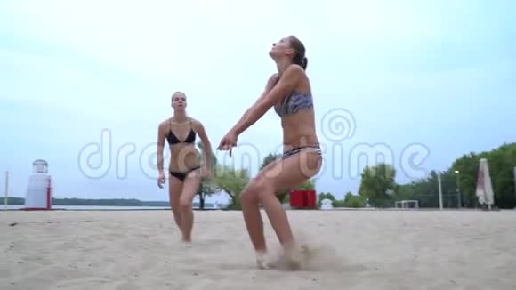 年轻运动女子在沙滩上打排球的慢镜头视频的预览图
