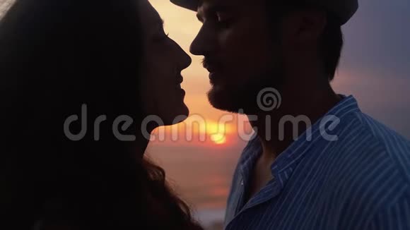 男人和女人拥抱的剪影在夕阳背景下接吻慢动作视频的预览图