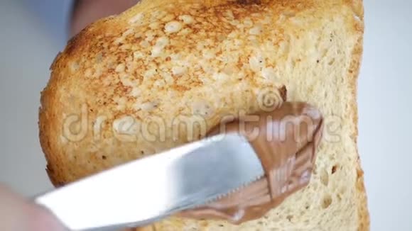 巧克力奶油在慢动作的烤面包片上展开视频的预览图