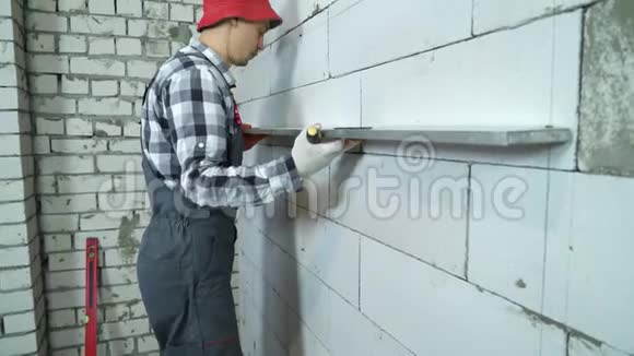 建筑工人将施工尺用于加气混凝土墙检查其标记视频的预览图