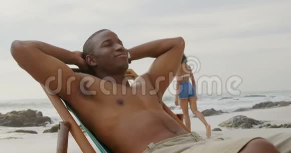 非裔美国人的正面景色让人放松眼睛紧闭在海滩上视频的预览图