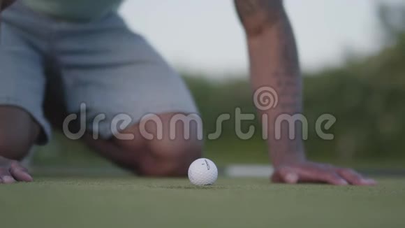 中东年轻人在高尔夫球场打高尔夫球一个英俊的男人在高尔夫球边吹球视频的预览图