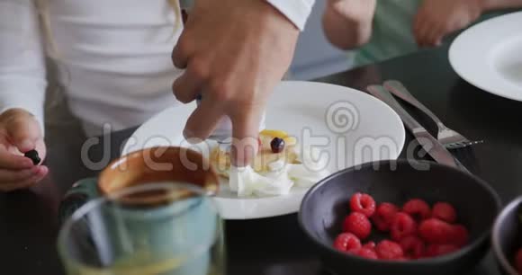 家庭在舒适的家中的餐桌上装饰食物视频的预览图