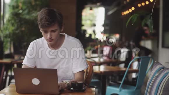 年轻人完成工作自由职业者和博客写手做平面设计师室内现代工作场所坐在咖啡馆视频的预览图