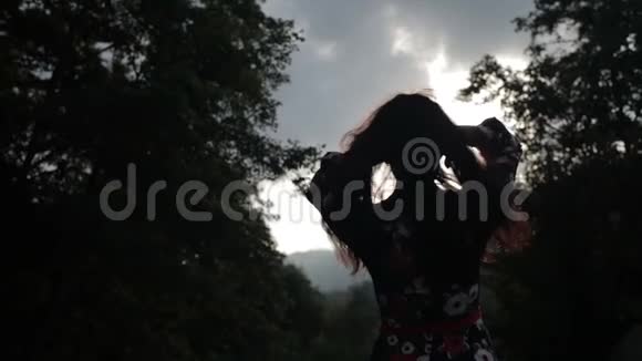 年轻女子在阳光下玩弄她的头发剪影视频的预览图