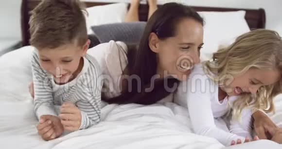 母亲在家里的卧室里和孩子们玩耍视频的预览图