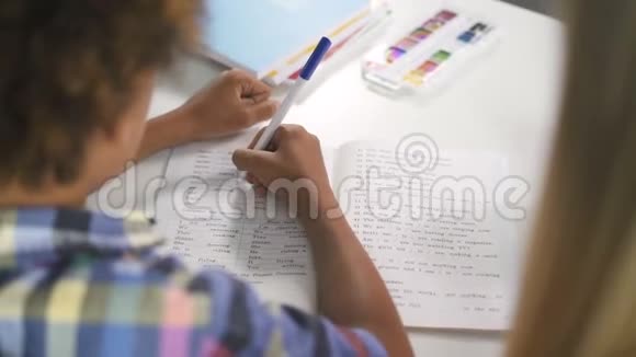 非洲男孩通过在笔记本上写正确的答案来学习语言视频的预览图