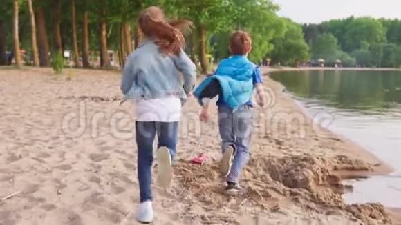 两个孩子沿着桑迪海岸跑视频的预览图