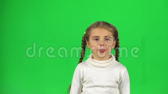 儿童玩耍做滑稽的脸在绿色屏幕上露出舌头视频的预览图