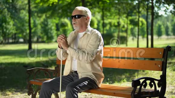 贫穷的盲人独自坐在公园里社会处境不利的人口视频的预览图