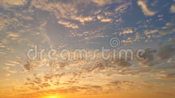 在黄昏时分橙色到红色的蓬松云在充满活力的蓝色日落天空上滚动大自然云景视频的预览图