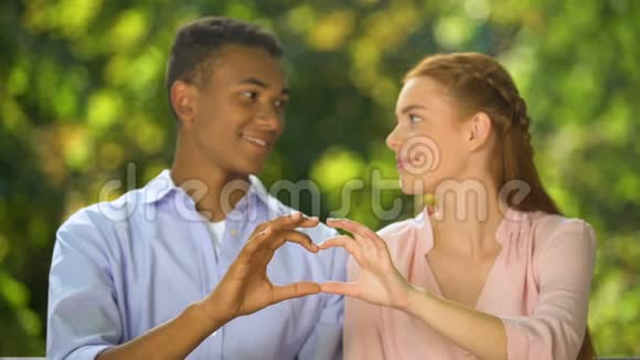 可爱的青少年用手做心脏标志看着镜头感情视频的预览图