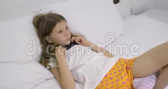 早上在床上女孩躺着遥控器看电视视频的预览图