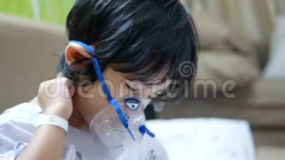 戴着呼吸面罩的亚洲小女孩吸入喷雾器里的药雾视频的预览图