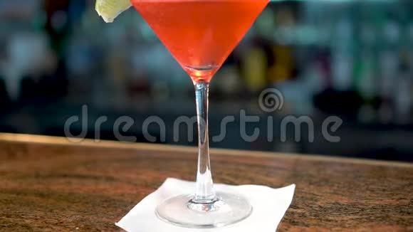 酒吧柜台上的马提尼酒杯中的红色饮料世界大都会鸡尾酒的特写视频的预览图