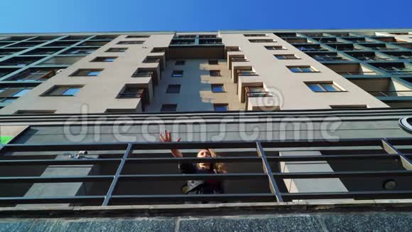 近现代建筑金属栏杆旁金色女性舞蹈低角度镜头视频的预览图