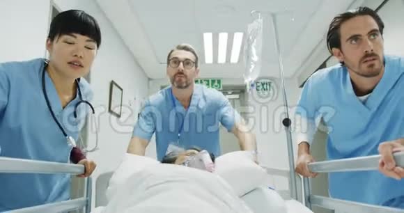 医院工作人员在紧急情况下将病人推到床上视频的预览图
