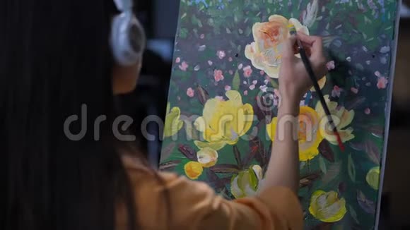 耳机里的女画家描绘大自然视频的预览图