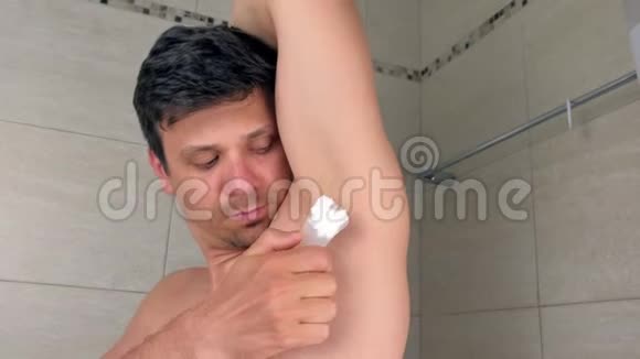 卫生间用抹刀在腋窝涂抹脱毛膏的人的肖像视频的预览图