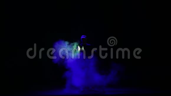 一个人在一阵烟雾中把一束光从聚光灯射进大厅视频的预览图