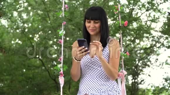 美丽的年轻女孩在互联网上用智能手机在街上交流视频的预览图
