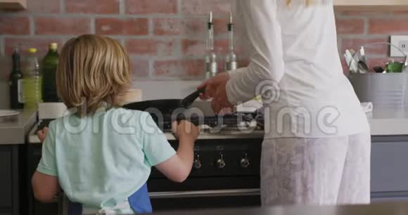 母亲和儿子在舒适的家厨房准备食物视频的预览图