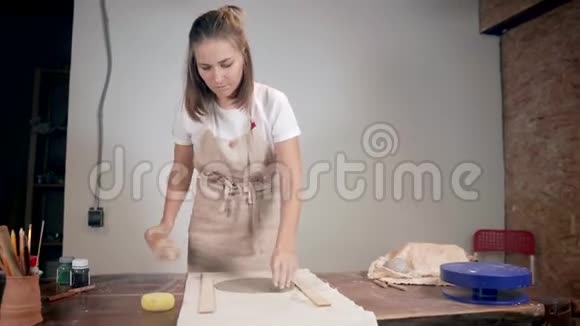 女人在陶艺工作室用擀面杖在桌子上展开粘土视频的预览图