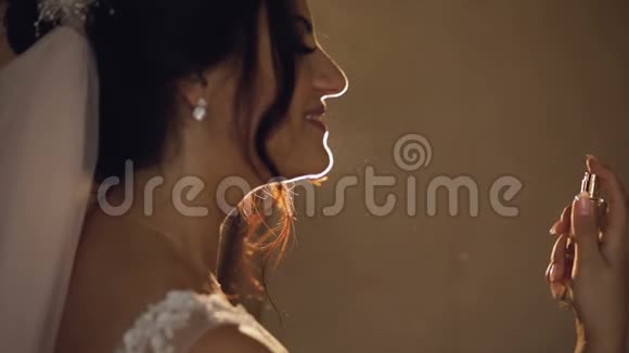 美丽的新娘把香水洒在自己身上结婚纪念日慢动作视频的预览图