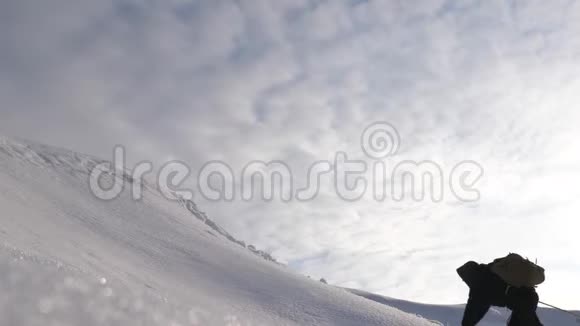 旅行者在一阵强风中爬着绳子穿过雪上坡走向胜利冬天的游客一起工作视频的预览图