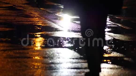 街头湿沥青背景雨衣男式剪影视频的预览图
