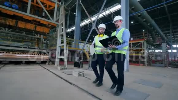 两名工业工人正穿过工厂设施视频的预览图