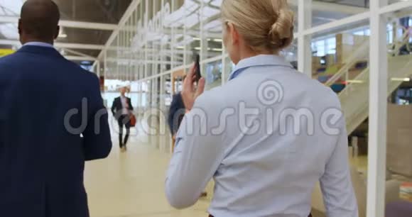 女商人用智能手机在会议大厅走动视频的预览图
