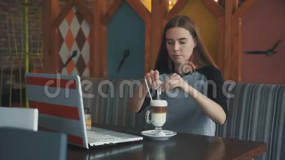 漂亮的商务女性在咖啡馆里的笔记本电脑后面工作等待咖啡视频的预览图
