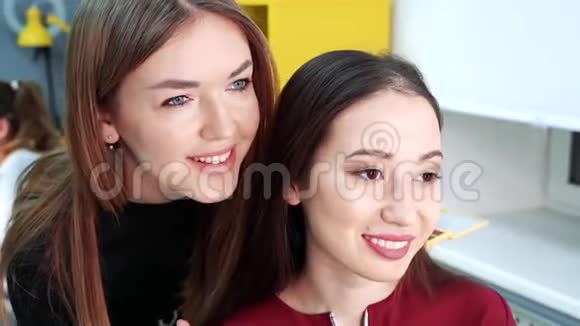 化妆师和模特照镜子在美容室微笑视频的预览图