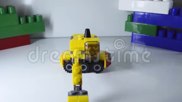 白色背景的黄色玩具设计师挖掘机在附近旋转视频的预览图