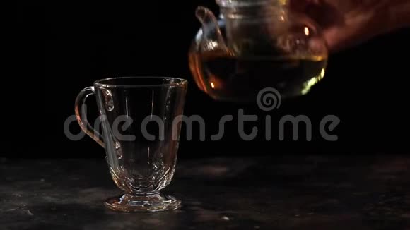 手把凉茶从茶壶到玻璃的黑暗背景视频的预览图